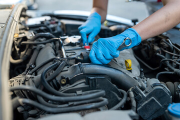 female car service technician inspects and repairs a customer's car at a car service center.