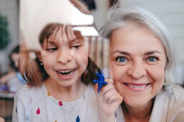Smiling grandmother with granddaughter seen through window