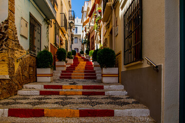 Fototapeta na wymiar antique staircase in Calpe, Spain in the old town painted red and yellow in the color of the country's flag
