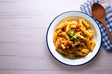 Pasta alla normal - Italian pasta with eggplant, tomato sauce and Parmesan cheese on dark background. Top view. Healthy food.