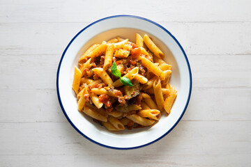 Pasta alla normal - Italian pasta with eggplant, tomato sauce and Parmesan cheese on dark background. Top view. Healthy food.
