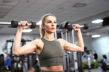Fototapeta na wymiar Blonde caucasian woman training with weights