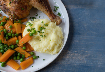 Plate with Crispy chicken leg with mashed potatoes and peas and carrots