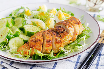 Grilled chicken meat and boiled eggs and fresh cucumber salad. Healthy keto, ketogenic lunch. Roasted chicken breast, fillet and fresh vegetable salad.