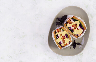 Sandwich with chicken fillet, red cabbage and sauce, wrapped in paper. Take along. Top view