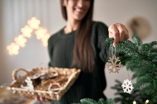 Caucasian woman decorating Christmas tree at home