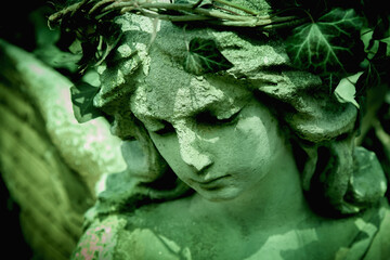 Close up fragile beautiful guardian angel in a wreath of ivy. Horizontal image.