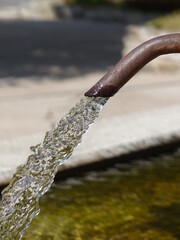 et d'eau limpide avec son bec deverseur rouillé remplissage une belle fontaine en Aveyron,