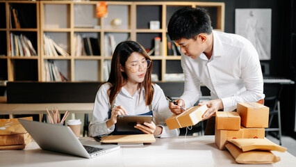 Starting small businesses SME owners, two check online orders Selling products working with boxs freelance work at home office using tablet and laptop  marketing, packaging, concept.