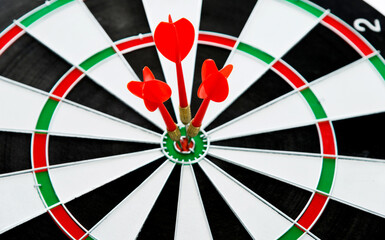 Three red dart arrows hitting in the target center