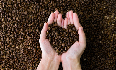 Coffee beans in hands of heart shaped