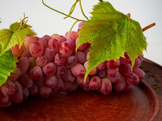 Ripe red grapes. Pink bunch with leaves isolated on white. With trajectory cropping. Full depth of...