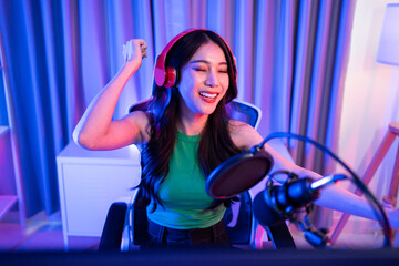 Asian young audio DJ woman sing a song on microphone to broadcasting. 