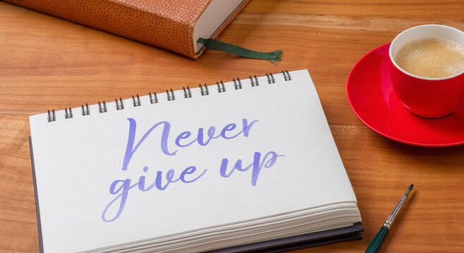  Notepad on a desk - Never give up