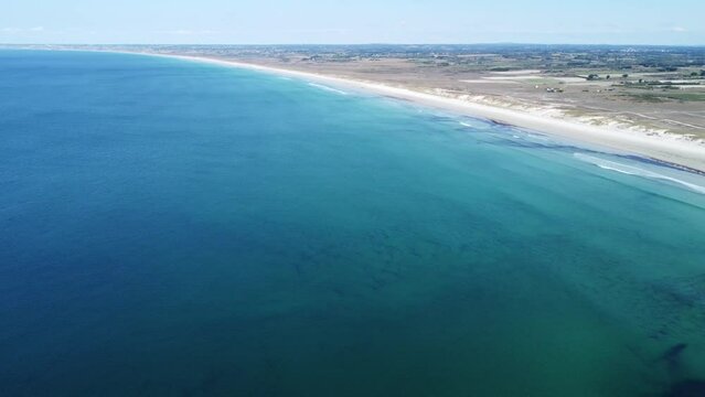 endlessly long and white sandy beach near la torche in brittany in france, filmed with a drone in perfect weather