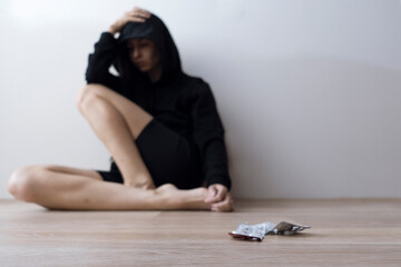 taking antidepressants during depression. mental health problems. a woman in a hood is sad. blurry man