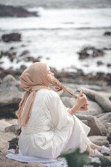 Muslim Woman Sitting at the Beach Enjoying Summer