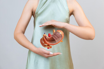 woman is holding mock stomach in the hands. Help and care concept