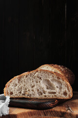 Fresh artisan sourdough bread on a cutting board. Close-up, vertical frame with copy space