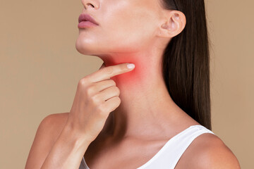Closeup of unrecognizable sick lady suffering from sore throat, touching neck with hand, inflamed red zone