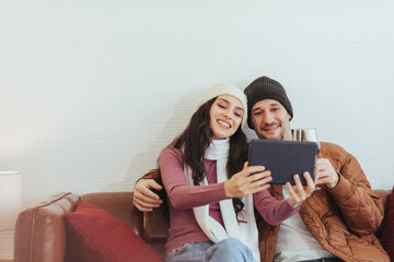 Couple love watching movie together at home. Happy couple love using digital tablet to video call celebrating with family. Romantic for Christmas winter.