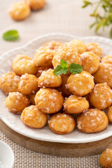 Delicious French Chouquette Choux Pastry dessert Pearl Sugar Puff on wooden table background.