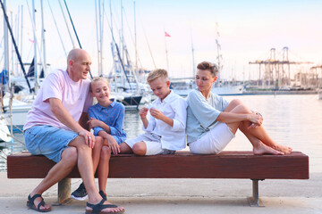 mom, dad, daughter and son happy family on sea marina background