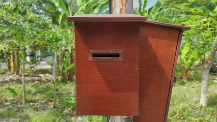 Object background of wooden mailbox on the pole near by garden of the house