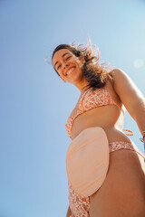 young girl with ostomy bag in bikini looking at camera
