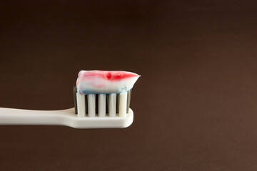 Toothbrush with toothpaste on a brown background. Dental care. Oral hygiene.