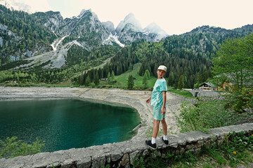 Boy stand against lake and mountains at Vorderer Gosausee, Gosau, Upper Austria.