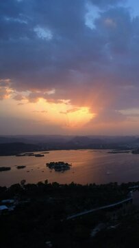 Evening view of Udaipur city skyline and lake Pichola vertical time lapse video seen from Udaipur view point. Udaipur city, Rajasthan, India.
