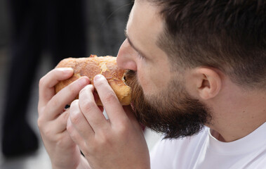 Young Hipster Male In Pub Eating Delicious Burger.