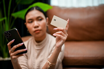Asian female holding a smartphone and a credit card. Online payment, online shopping