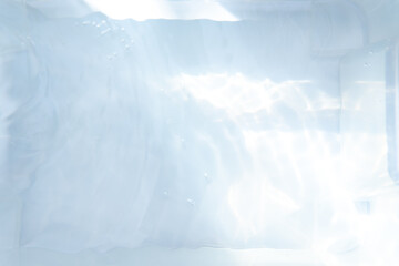 Blurred ripple water texture on white background. Shadow of water on sunlight. Mockup for product, spa or travel background. Marble water surface as wallpaper background