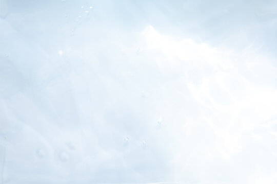 Blurred ripple water texture on white background. Shadow of water on sunlight. Mockup for product, spa or travel background. Marble water surface as wallpaper background