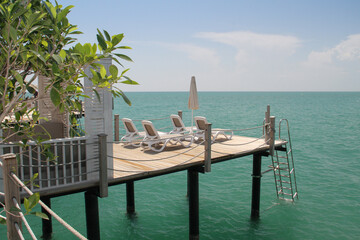 Paradise vacation. Empty sunbeds on the pier by the sea.
