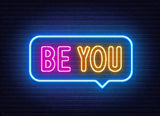 Be You neon sign in the speech bubble on brick wall background.