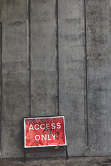 A concrete wall with Access Only road Sign