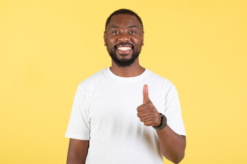 Happy African American Guy Gesturing Thumbs Up Posing, Yellow Background