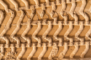 Tyre tracks on brown sand in construction site