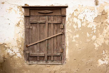 Old wooden window with shutters. Old clay house.