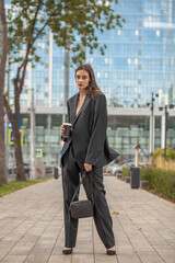 Young sexy woman in male business suit posing on the street