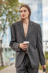 Young sexy woman in male business suit posing on the street