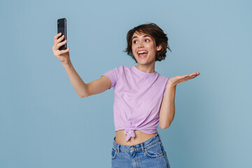 White woman holding copyspace while taking selfie at cellphone