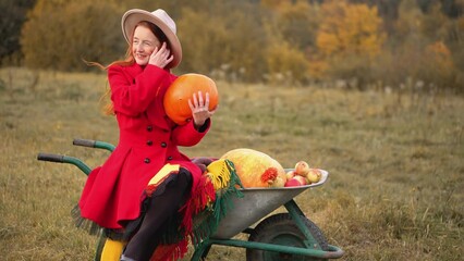 Redhead woman in red and autumn Thanksgiving still life with plaid, pumpkins and apples. A girl in orange rests in nature with a dog. Autumn weekend idea, bachelorette party, date night, harvest day. - Powered by Adobe