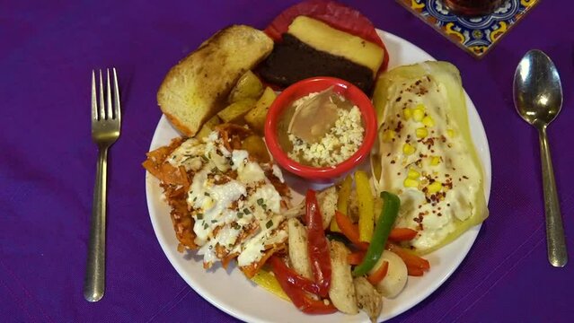 delicious Mexican dish of chicken fajitas with tamale au gratin, toasted bread with butter, beans in the center and dessert
