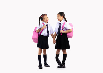 Primary and junior school girl in student uniform with pink bagpacks posing standing full length on...