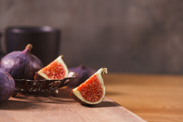 Fresh ripe figs in vase on wooden background. Autumn fruit harvest