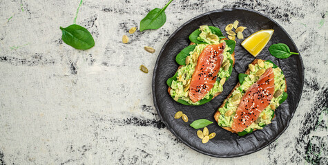 Delicious breakfast or snack sandwich salmon, avocado, spinach, nuts, sunflower seeds, toast with...